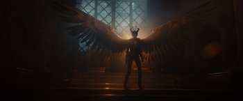 Movie still from “Maleficent” (2014), directed by Robert Stromberg – A person with a large wing in a dark room; Wide shot, Low angle