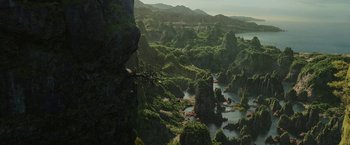 Movie still from “Maleficent: Mistress of Evil” (2019), directed by Joachim Rønning – An aerial view of a lake surrounded by mountains and trees; Extreme Wide shot, High angle