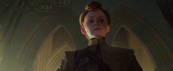 Movie still from “Maleficent: Mistress of Evil” (2019), directed by Joachim Rønning – A young girl in a dress stands in a room; Close Up shot, Low angle