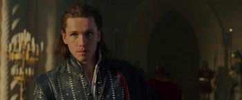 Movie still from “Maleficent: Mistress of Evil” (2019), directed by Joachim Rønning – A man with long brown hair wearing a black and red jacket; Close Up shot, Over the shoulder angle