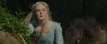 Movie still from “Maleficent: Mistress of Evil” (2019), directed by Joachim Rønning – A woman in a blue dress standing next to a bush; Close Up shot, Over the shoulder angle