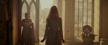 Movie still from “Maleficent: Mistress of Evil” (2019), directed by Joachim Rønning – A woman in a white dress standing in front of a window; Medium shot, Low angle