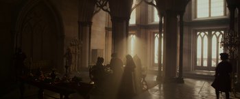 Movie still from “Maleficent: Mistress of Evil” (2019), directed by Joachim Rønning – A group of people sitting around a table in a room; Extreme Wide shot, Over the shoulder angle