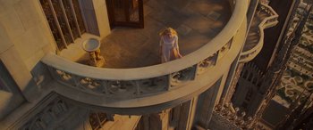 Movie still from “Maleficent: Mistress of Evil” (2019), directed by Joachim Rønning – A woman in a white dress standing on a balcony; Wide shot, Overhead angle