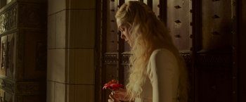 Movie still from “Maleficent: Mistress of Evil” (2019), directed by Joachim Rønning – A woman holding a flower in her hands; Close Up shot, Over the shoulder angle