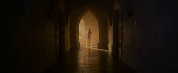 Movie still from “Maleficent: Mistress of Evil” (2019), directed by Joachim Rønning – A woman walking through an archway in a building; Wide shot, Low angle