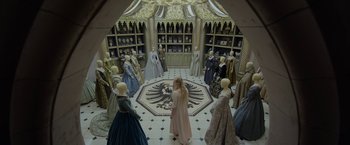 Movie still from “Maleficent: Mistress of Evil” (2019), directed by Joachim Rønning – A group of people standing in a room with many dresses; Extreme Wide shot, High angle