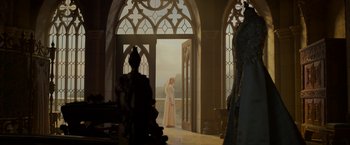 Movie still from “Maleficent: Mistress of Evil” (2019), directed by Joachim Rønning – A woman in a white dress standing in front of an open door; Wide shot, Low angle