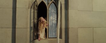 Movie still from “Maleficent: Mistress of Evil” (2019), directed by Joachim Rønning – A woman leaning up against a window sill; Medium shot, Low angle