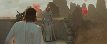Movie still from “Maleficent: Mistress of Evil” (2019), directed by Joachim Rønning – A woman dressed as a princess standing next to a stone wall; Wide shot, Over the shoulder angle