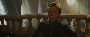 Movie still from “Maleficent: Mistress of Evil” (2019), directed by Joachim Rønning – A woman in a black dress is sitting on a balcony; Close Up shot, Low angle