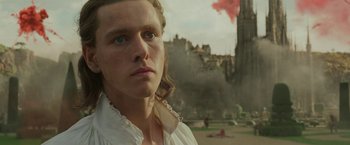 Movie still from “Maleficent: Mistress of Evil” (2019), directed by Joachim Rønning – A man in a white shirt is standing in front of a castle; Close Up shot, Low angle