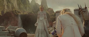 Movie still from “Maleficent: Mistress of Evil” (2019), directed by Joachim Rønning – A woman dressed in a white dress standing in front of mountains; Wide shot, Over the shoulder angle
