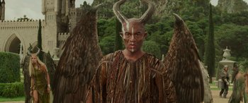 Movie still from “Maleficent: Mistress of Evil” (2019), directed by Joachim Rønning – A man with horns is standing in front of trees; Medium shot, Low angle