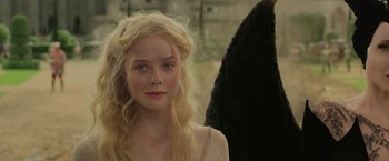Movie still from “Maleficent: Mistress of Evil” (2019), directed by Joachim Rønning – A beautiful young blonde woman wearing a long dress; Close Up shot, Over the shoulder angle