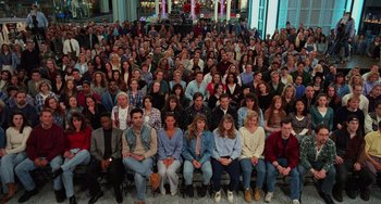 A large group of people sitting in front of a building