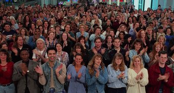 A large group of people clapping in front of a crowd