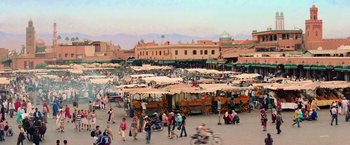 Movie still from “Mamma Mia!” (2008), directed by Phyllida Lloyd – A group of people walking around a market area; Extreme Wide shot, High angle