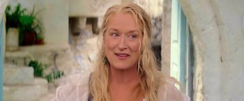 Movie still from “Mamma Mia!” (2008), directed by Phyllida Lloyd – A person with long blonde hair; Close Up shot, Over the shoulder angle