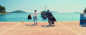 Movie still from “Mamma Mia!” (2008), directed by Phyllida Lloyd – Two men are running towards a boat on the water; Wide shot, Low angle