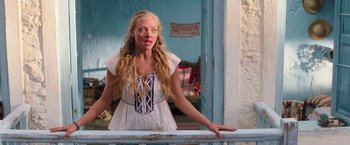 Movie still from “Mamma Mia!” (2008), directed by Phyllida Lloyd – A woman with long blonde hair standing next to a railing; Medium shot, Over the shoulder angle