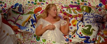 Movie still from “Mamma Mia!” (2008), directed by Phyllida Lloyd – A woman laying on the ground with her eyes closed; Medium shot, Overhead angle