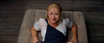 Movie still from “Mamma Mia!” (2008), directed by Phyllida Lloyd – A woman is laying on a couch smiling for the camera; Medium shot, High angle