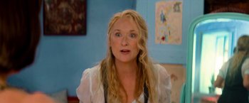 Movie still from “Mamma Mia!” (2008), directed by Phyllida Lloyd – A woman with long blonde hair is looking at the camera; Close Up shot, Over the shoulder angle