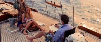 Movie still from “Mamma Mia!” (2008), directed by Phyllida Lloyd – A man and a woman sitting on the deck of a sailboat; Wide shot, High angle
