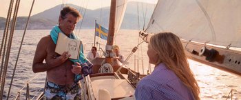 Movie still from “Mamma Mia!” (2008), directed by Phyllida Lloyd – A woman sitting on the deck of a sail boat; Medium shot, Over the shoulder angle