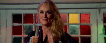 Movie still from “Mamma Mia!” (2008), directed by Phyllida Lloyd – A woman with long blonde hair holding a pen; Close Up shot, Over the shoulder angle