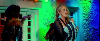 Movie still from “Mamma Mia!” (2008), directed by Phyllida Lloyd – A woman in a black and white dress singing; Medium shot, Low angle