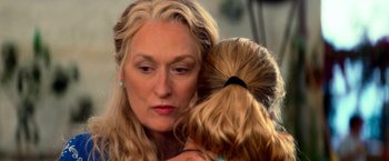 Movie still from “Mamma Mia!” (2008), directed by Phyllida Lloyd – A person holding a child; Close Up shot, Over the shoulder angle