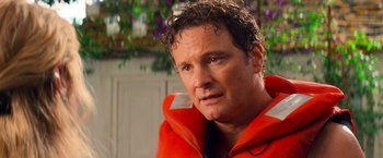 Movie still from “Mamma Mia!” (2008), directed by Phyllida Lloyd – A person wearing an orange jacket; Close Up shot, Over the shoulder angle