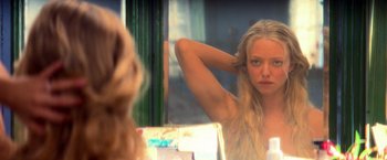 Movie still from “Mamma Mia!” (2008), directed by Phyllida Lloyd – A woman looking in the mirror in front of a window; Close Up shot, Over the shoulder angle