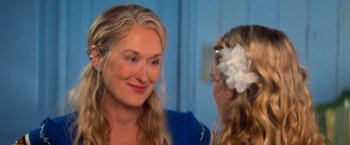 Movie still from “Mamma Mia!” (2008), directed by Phyllida Lloyd – A woman with long blonde hair looking into a mirror with a flower in her hair; Close Up shot, Over the shoulder angle