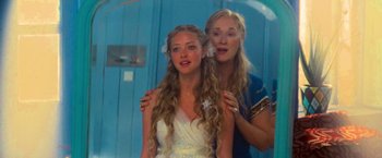 Movie still from “Mamma Mia!” (2008), directed by Phyllida Lloyd – A woman and a young girl posing for a picture; Close Up shot, Over the shoulder angle