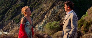 Movie still from “Mamma Mia!” (2008), directed by Phyllida Lloyd – A man and a woman standing on top of a hill; Medium shot, Low angle