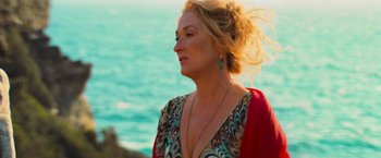 Movie still from “Mamma Mia!” (2008), directed by Phyllida Lloyd – A woman standing next to a body of water; Close Up shot, Over the shoulder angle