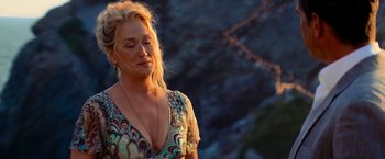 Movie still from “Mamma Mia!” (2008), directed by Phyllida Lloyd – A woman with blonde hair is standing in front of a cliff; Close Up shot, Low angle