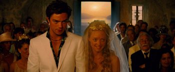 Movie still from “Mamma Mia!” (2008), directed by Phyllida Lloyd – A man and a woman standing next to each other; Medium shot, Over the shoulder angle