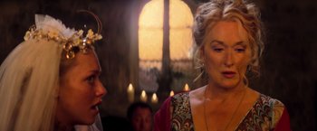 Movie still from “Mamma Mia!” (2008), directed by Phyllida Lloyd – Two women are talking to each other in front of a window; Close Up shot, Over the shoulder angle