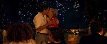 Movie still from “Mamma Mia!” (2008), directed by Phyllida Lloyd – A man and a woman kissing in front of a fireworks display; Medium shot, High angle