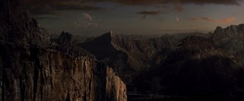 Movie still from “Man of Steel” (2013), directed by Zack Snyder – A view of a mountain range at night with the moon in the distance; Extreme Wide shot, High angle