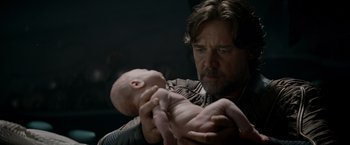 Movie still from “Man of Steel” (2013), directed by Zack Snyder – A man holding a baby in his arms; Close Up shot, Over the shoulder angle
