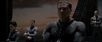 Movie still from “Man of Steel” (2013), directed by Zack Snyder – A man in a black suit and a man in a black suit and a man in a black suit and a man in a black suit; Close Up shot, Low angle