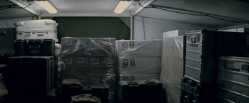 Movie still from “Man of Steel” (2013), directed by Zack Snyder – A room filled with boxes and luggage wrapped in plastic; Wide shot, High angle