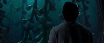 Movie still from “Man of Steel” (2013), directed by Zack Snyder – A man standing in front of an aquarium looking at fish; Medium shot, Over the shoulder angle