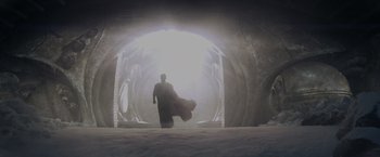 Movie still from “Man of Steel” (2013), directed by Zack Snyder – A man in a black cape is standing in front of a tunnel; Extreme Wide shot, Low angle