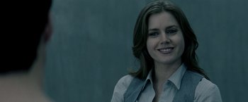 Movie still from “Man of Steel” (2013), directed by Zack Snyder – A person wearing a shirt and tie smiling; Close Up shot, Over the shoulder angle